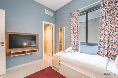 a living room with a couch and a tv at Charming 3BR Townhouse with Study Room in Damac Hills 2 Centaury, Dubailand By Deluxe Holiday Homes in Dubai
