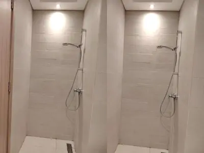 a bathroom with a shower with glass doors at Netflix and Wi-Fi Studio Pool, Gym & City Views in Dubai