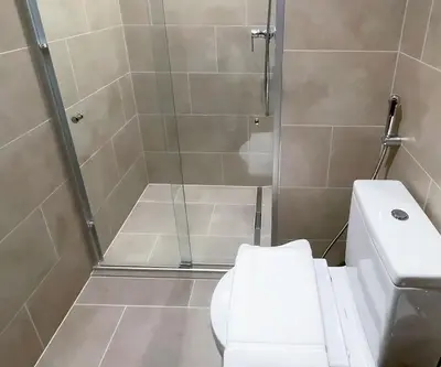 a bathroom with a shower with a toilet and a sink at Fast Wi-fi Netflix Cozy 1BR Flat Near Downtown Dubai in Dubai