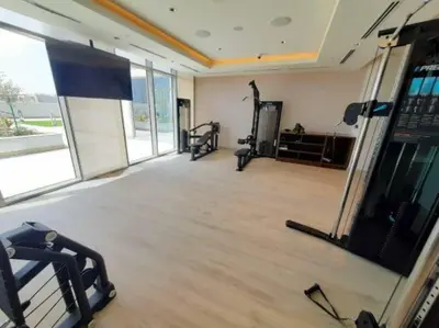 a gym with two treadmills and a simulator at Fast Wi-fi Netflix Cozy 1BR Flat Near Downtown Dubai in Dubai