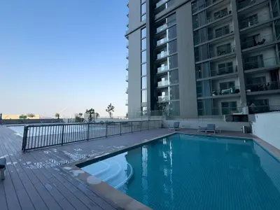 a swimming pool in front of a tall building at Pet free 1BR with Balcony Pool Gym Near Downtown in Dubai