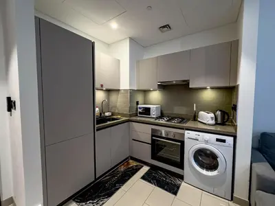 a kitchen with a washing machine and a washer at Pet free 1BR with Balcony Pool Gym Near Downtown in Dubai