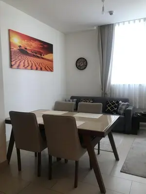 a dining table and chairs in a living room at Pet free 1BR with Balcony Pool Gym Near Downtown in Dubai