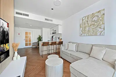 a white living room with a couch and a table at Stunning 2 Bed Great Metro access in Dubai