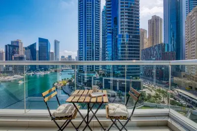 a balcony with a table and chairs and a view of a city at ShoresInn - Beautiful residence with Marina Views in Dubai