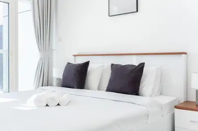 a bedroom with a white bed with two rolled towels at ShoresInn - Beautiful residence with Marina Views in Dubai