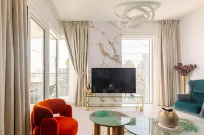 a living room with a television and a table and chairs at LA VIE JBR, Sea & Palm View Apartment in Dubai