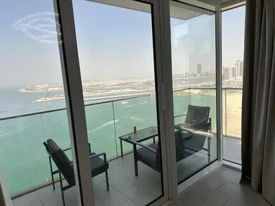 a balcony with a table and chairs and a view of the ocean at LA VIE JBR, Sea & Palm View Apartment in Dubai
