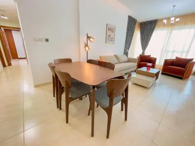 a living room with a wooden table and chairs at Luxury Holiday Home Just Minutes from Dubai's Global Village Your Perfect Getaway!