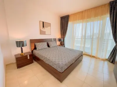 a bedroom with a bed and a large window at Luxury Holiday Home Just Minutes from Dubai's Global Village Your Perfect Getaway!