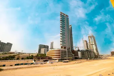 a tall building on the beach next to a beach at BRAND NEW Studio in Azizi Riviera in Dubai
