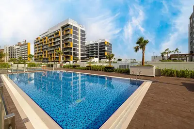 a large swimming pool with buildings in the background at BRAND NEW Studio in Azizi Riviera in Dubai