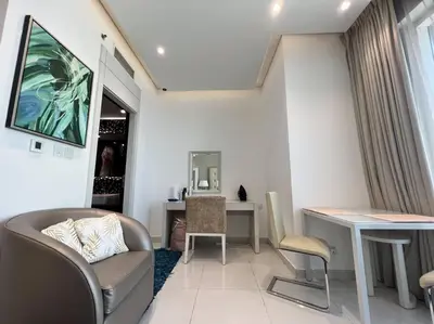 a living room with a chair and a table and a desk at In Vogue Live On the Canal in Business Bay in Dubai