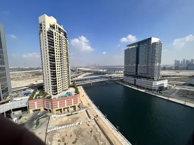 a view of a city with tall buildings and a river at In Vogue Live On the Canal in Business Bay in Dubai
