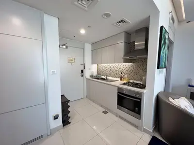 a kitchen with a sink and a stove top oven at In Vogue Live On the Canal in Business Bay in Dubai