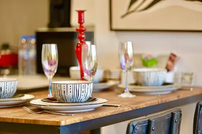a table with plates and wine glasses on it at Gorgeous 2BR with full Burj Khalifa view, 5 mins from Dubai Mall in Dubai