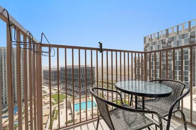 a patio with a table and chairs on a balcony at WelHome - Beautiful 1BR Apt in Dubai Hills with City View in Dubai