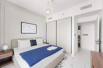 a bedroom with a large bed with blue and white sheets at Silkhaus Family Ideal & High Floor 2BDR in Dubai