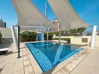 a swimming pool with umbrellas on a building at Sky High Luxury 50th FLR Lux 2BDR Apartment in Downtown in Dubai