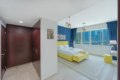 a bedroom with a bed and a yellow chair at Full Sea View in Dubai Marina - Balcony & Pool in Dubai