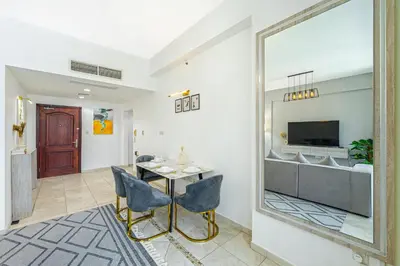 a living room with a table and chairs and a mirror at Full Sea View in Dubai Marina - Balcony & Pool in Dubai