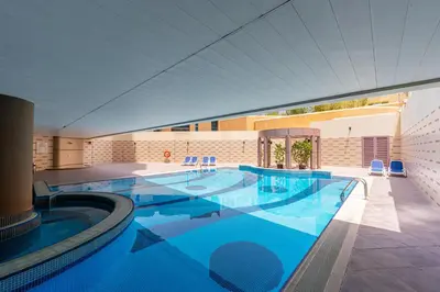 a large swimming pool with blue water in a building at Full Sea View in Dubai Marina - Balcony & Pool in Dubai