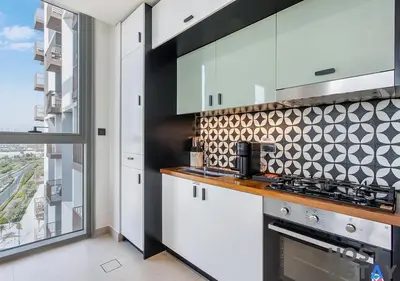 a kitchen with a stove top oven next to a window at Elegant 2-BR Retreat In Dubai Hills in Dubai