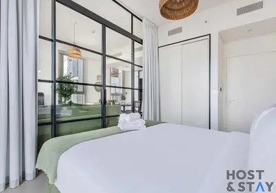 a bedroom with a bed and a large window at Elegant 2-BR Retreat In Dubai Hills in Dubai