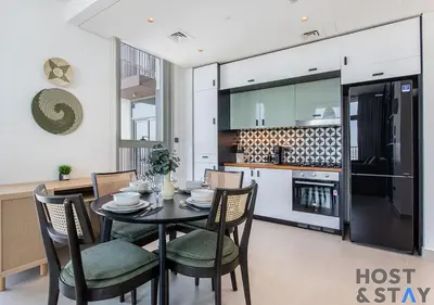 a dining room with a table and chairs in a kitchen at Elegant 2-BR Retreat In Dubai Hills in Dubai