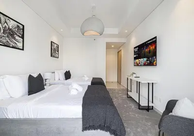 a bedroom with two beds and a desk in it at Bright High Floor Apartment in a 5 Star Hotel Resident Tower w Burj View and access to 64th Infinity Pool, Gym, Sauna, Spa, Restaurants, Bars and more in Dubai