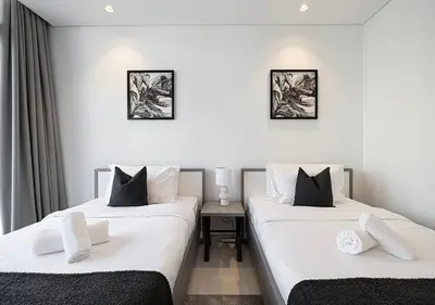 two beds in a room with white walls at Bright High Floor Apartment in a 5 Star Hotel Resident Tower w Burj View and access to 64th Infinity Pool, Gym, Sauna, Spa, Restaurants, Bars and more in Dubai