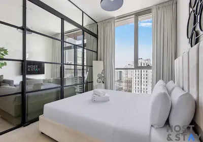 a bedroom with a white bed and a large window at Chic Urban 2BR at Collective 2 in Dubai