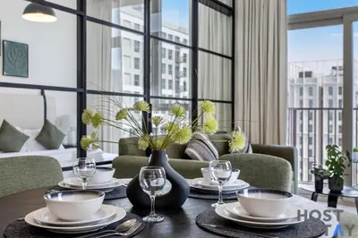 a dining room with a table with plates and wine glasses at Chic Urban 2BR at Collective 2 in Dubai