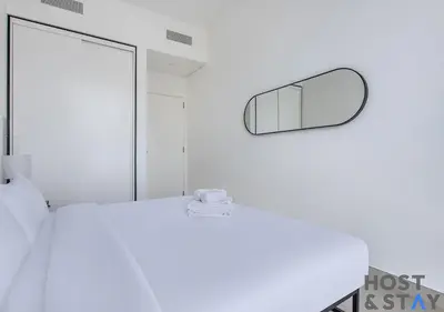 a bedroom with a white bed and a mirror at Chic Urban 2BR at Collective 2 in Dubai