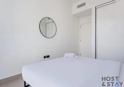 a white room with a mirror and a table at Upgraded 2BR In Dubai Hills in Dubai