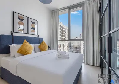 a bedroom with a large white bed and a large window at Upgraded 2BR In Dubai Hills in Dubai