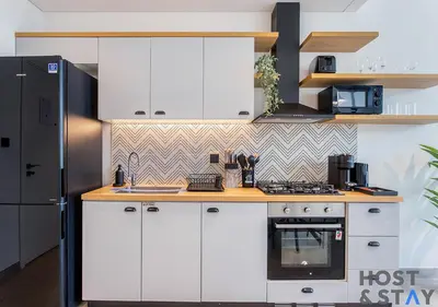 a kitchen with white cabinets and a stove at Modern 1bed Haven in Dubai Hills in Dubai