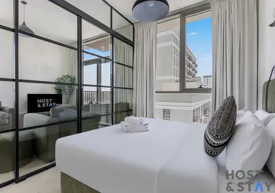 a bedroom with a bed and a living room at Minimalist 2BR in Dubai Hills in Dubai