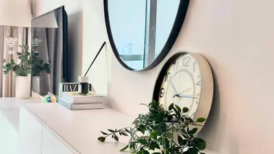 a clock on a wall next to a mirror at Luxury Family Studio Close to Dubai Mall and Burj Khalifa in Dubai