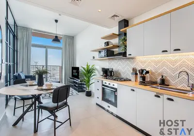 a kitchen with a table and chairs and a dining room at Serene 1BR Getaway In Collective in Dubai