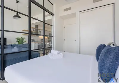 a bedroom with a white bed and a large mirror at Serene 1BR Getaway In Collective in Dubai