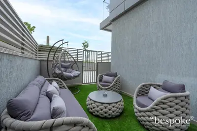 a patio with two wicker chairs and a table at Bespoke Holiday Homes - Sobha Creek Vistas Reserve in Dubai