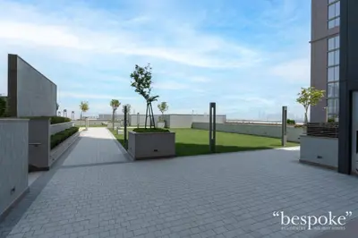 a walkway with trees on the side of a building at Bespoke Holiday Homes - Sobha Creek Vistas Reserve in Dubai