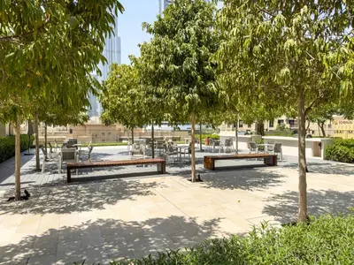 a park with benches and tables and trees at The Burj Khalifa Suite Luxury 2-bed in Burj Royale in Dubai