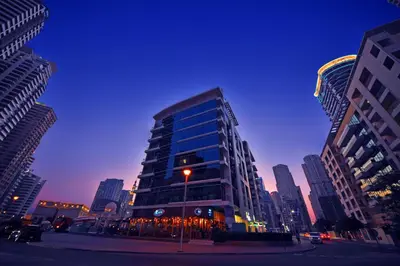 a tall glass building in a city at night at Jannah Place Dubai Marina in Dubai