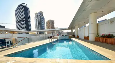 a swimming pool on the roof of a building with tall buildings at Jannah Place Dubai Marina in Dubai