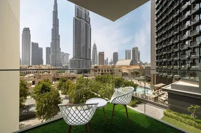 a balcony with a table and chairs and a view of a city at 2 BR Dubai Luxury apartment Full Burj Views in Dubai
