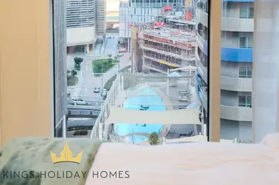 a bedroom with a bed and a window with a kings holiday homes sign at Dunya tower 2 downtown burj khalifa street Kings in Dubai
