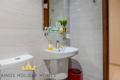 a bathroom with a sink and a toilet and a mirror at Dunya tower 2 downtown burj khalifa street Kings in Dubai
