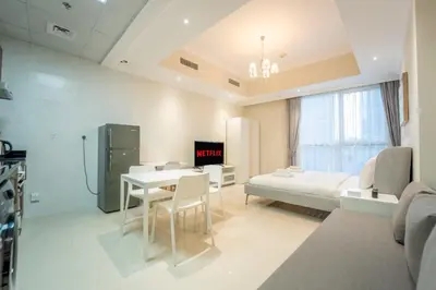 a room with a bed and a table and chairs at AWS Holiday Homes - In the Heart of Downtown in Dubai